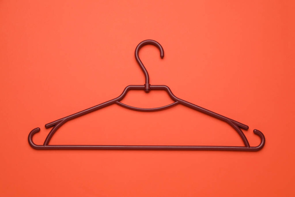 Empty clothes hanger on red background, top view - Foto, afbeelding