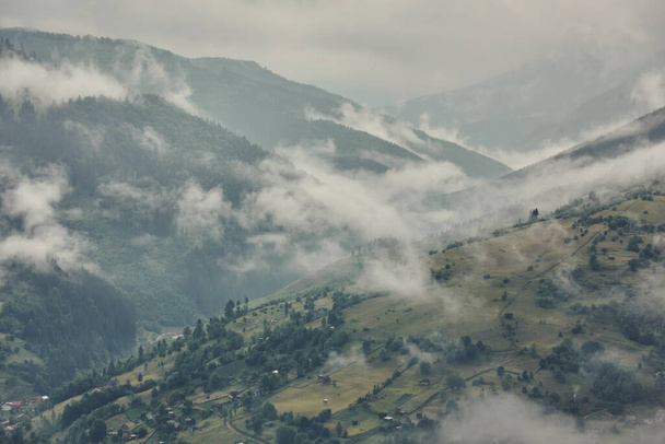 Majestic θέα σε όμορφα βουνά ομίχλη στην ομίχλη τοπίο. Δραματική ασυνήθιστη σκηνή. Ταξιδιωτικό υπόβαθρο. Εξερευνώντας τον κόσμο της ομορφιάς. Καρπάθια βουνά. Ουκρανία. Ευρώπη. - Φωτογραφία, εικόνα
