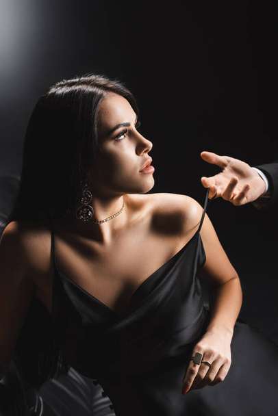 Man taking off dress from seductive girlfriend on black background - Photo, image