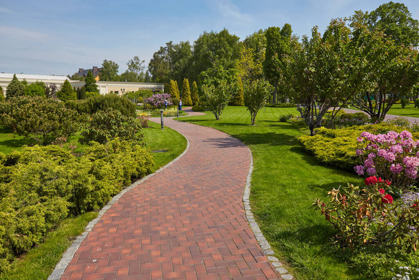 schöner Sommergarten mit einem sich schlängelnden Fußweg - Foto, Bild