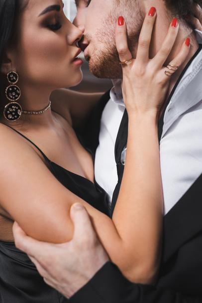Side view of sexy couple in formal wear kissing in elevator  - Foto, Imagen