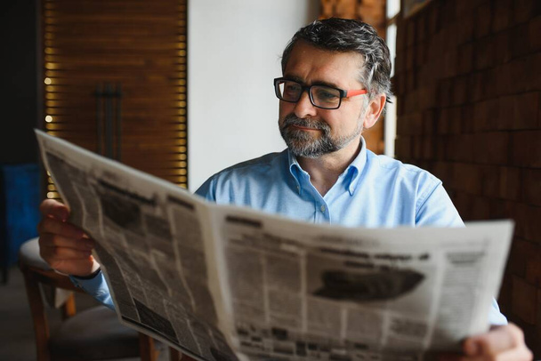 Business man reading a newspaper, cafe backgrounds. - Foto, imagen