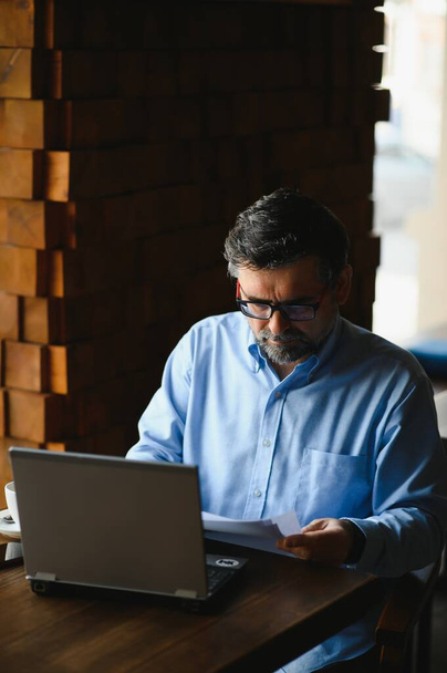 Senior male freelancer working on laptop in cafe. remote work concept - Foto, Bild