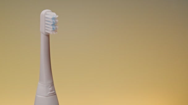 Elektrische ultrasone tandenborstel op veranderende kleur achtergrond. - Video
