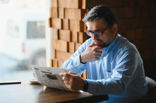 Business man reading a newspaper, cafe backgrounds. - Photo, Image