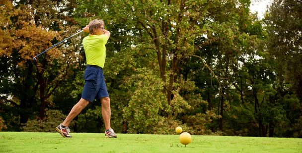 Golfista con palo de golf golpeando la pelota para el tiro perfecto. Golfista en un campo de golf, listo para salir. - Foto, Imagen
