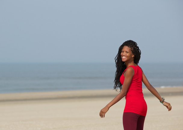 Smiling african american woman walking at the beach - Photo, Image