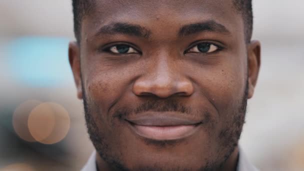 Headshot nuori onnellinen positiivinen afrikkalainen amerikkalainen liikemies yrityksen edustaja katselee kameraa luottavainen osoittaa täydellinen terve hammas hymy mainonta hammaslääkärin menettely mies muotokuva - Materiaali, video