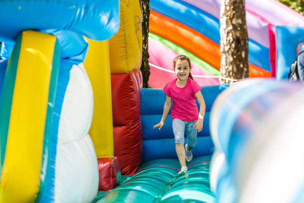 Little Girl sliding down an inflatable Slide - Photo, Image