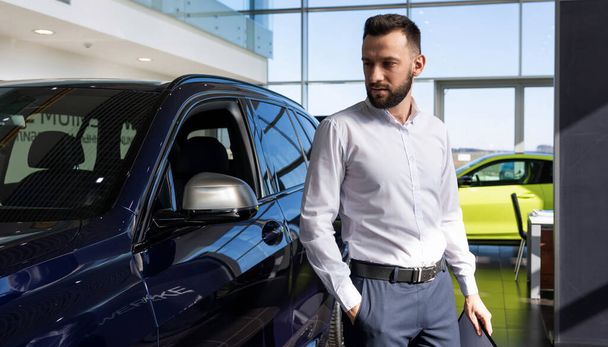 бизнесмен в автосалоне ищет новую машину - Фото, изображение