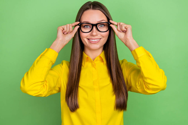 Photo of young pretty woman hands touch eyeglasses clever oculist isolated over green color background - Фото, зображення