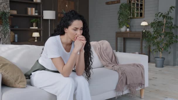 Excited frustrated stressed young woman sitting in room on couch thought sadly learned bad news worry about trouble with health thinking of personal problem feeling lonely suffering from depression - Imágenes, Vídeo