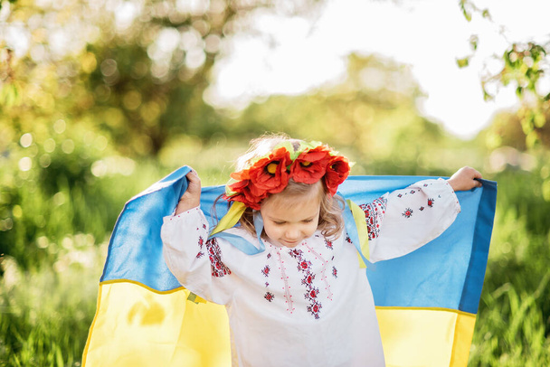 Ukrainian child with yellow and blue flag of Ukraine. flag symbol of Ukraine. Family, unity, support - Foto, imagen