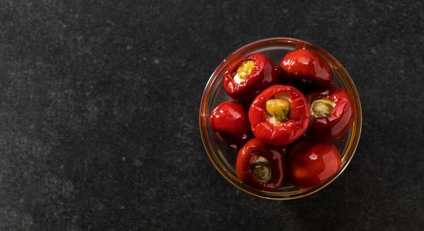 Red Chilli stuffed with Ricotta and Capers in oil, top view, banner, space for text - 写真・画像