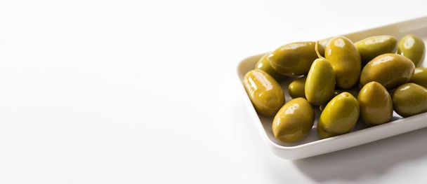Green pickled olives on a white background, banner, space for text - Foto, afbeelding