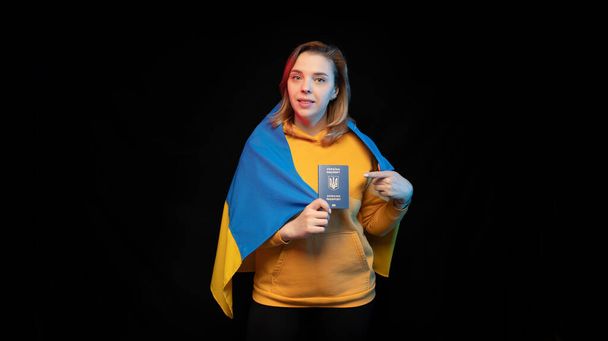 Hermosa chica ucraniana con la bandera nacional del estado de Ucrania sobre fondo negro. Copiar espacio. Guerra Ruso Ucraniana. Ayuda y reza por Ucrania. Alto a la guerra. - Foto, imagen