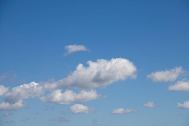 Яркое голубое небо со множеством красивых белых облаков для фона или обоев. Красота природы для графического дизайна, природной красоты, экологии и чистого воздуха. Естественные текстуры. - Фото, изображение