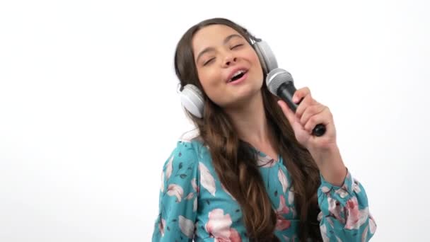 Lächelnder Kindersängerkünstler singt Lieder ins Mikrofon Musik hören mit Kopfhörern, Gesang - Filmmaterial, Video