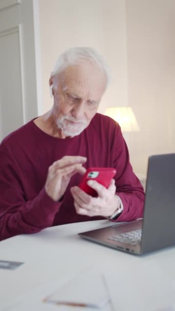 Der alte Mann blättert die Nachrichten am Telefon durch. Er lernt gerade, mit einem neuen Gerät umzugehen. Hochwertiges FullHD-Filmmaterial - Filmmaterial, Video