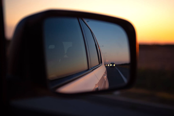 道路コピースペースの車のリアミラーの日没の反射 - 写真・画像