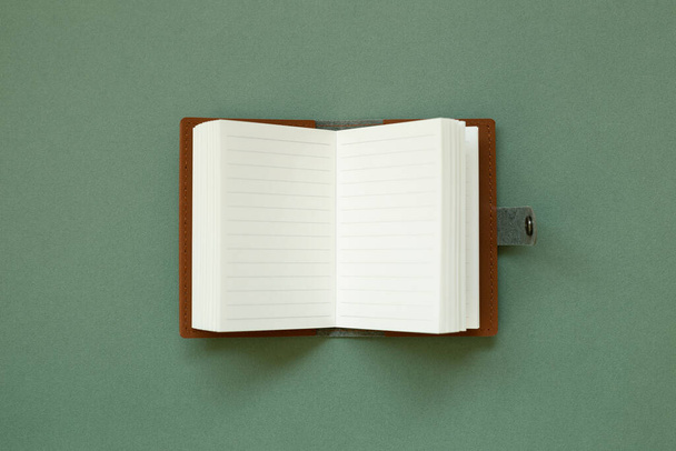 Blank notebook on green background. top view, copy space - Photo, Image