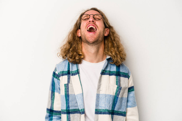 Jonge blanke man geïsoleerd op witte achtergrond ontspannen en gelukkig lachen, nek gestrekt tonen tanden. - Foto, afbeelding