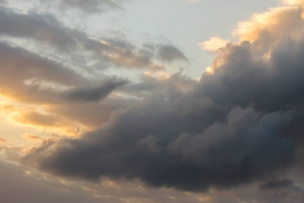 witte wolken in de blauwe lucht, gebroken door gouden zonnestralen bij zonsondergang. Tenerife, Canarische Eilanden. Spanje - Foto, afbeelding
