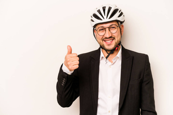 Business latino mies yllään kypärä pyörä eristetty valkoisella taustalla hymyillen ja nostamalla peukalo ylös - Valokuva, kuva