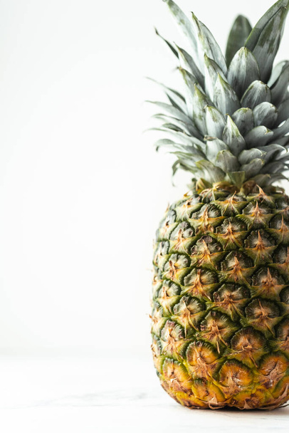 Whole pineapple isolated on the white background. Summertime background with tropic feel - Foto, Bild