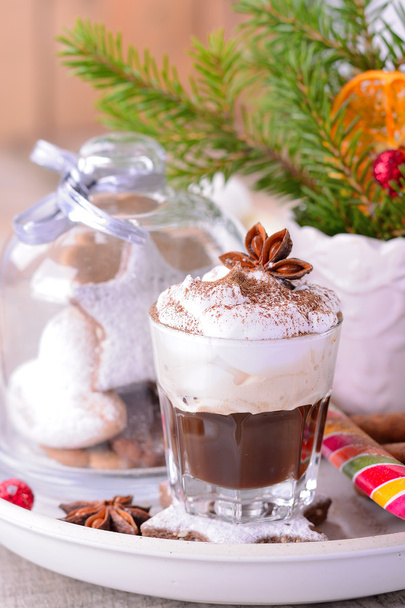Winter whipped cream hot coffee in a glass cup with anise and cinnamon - Фото, изображение