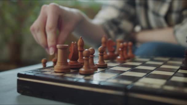 Una donna si prepara per una partita a scacchi e mette pezzi di scacchi bianchi sulla scacchiera. Filmati 4k di alta qualità - Filmati, video