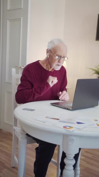 El pensionista escucha su música favorita. Escucha canciones desde la computadora a través de auriculares. Él gesticula y se comporta imprudentemente. Imágenes FullHD de alta calidad - Imágenes, Vídeo