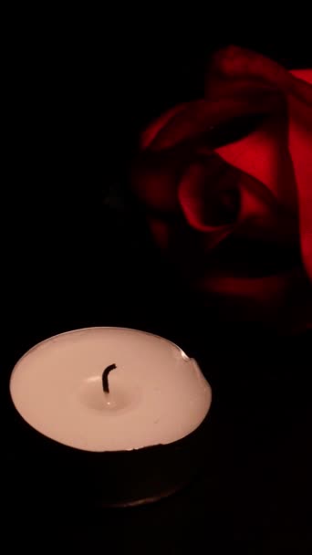 Rozen en brandende kaarsen op zwarte achtergrond als symbool rouwen, geheugen of Valentijnsdag. - Video