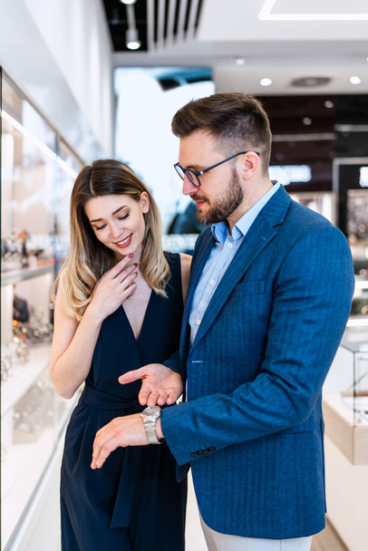 Beautiful couple enjoying in shopping at modern jewelry store. Men fashion and elegance  concept. - Photo, Image