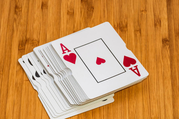 Hrací karty zblízka, izolované na dřevěném stole. Kasino koncept, riziko, šance, hodně štěstí nebo hazardní hry. - Fotografie, Obrázek