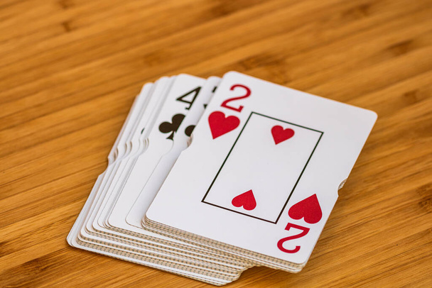 Speelkaarten van dichtbij, geïsoleerd op houten tafel. Casino concept, risico, kans, veel geluk of gokken. - Foto, afbeelding