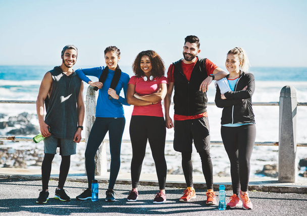 Our dedication is what keeps us together. Shot of a fitness group standing together while out for a run. - Photo, image