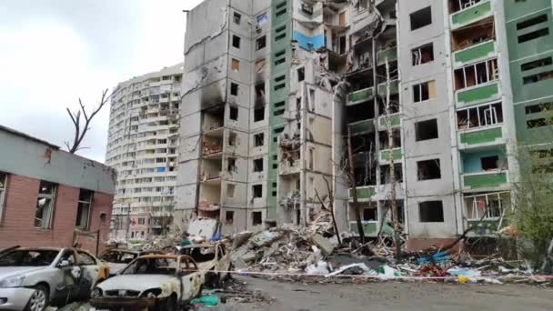 Chernihiv, Ucrânia - 17 de abril de 2022: Ataque aéreo em uma área residencial e na população civil da cidade. Guerra da Rússia contra a Ucrânia. Um homem passa por um prédio de apartamentos destruído na Ucrânia. - Filmagem, Vídeo