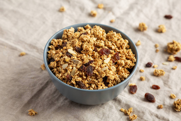 Homemade Granola with raisins and almonds  in a Bowl, side view.  - Фото, изображение