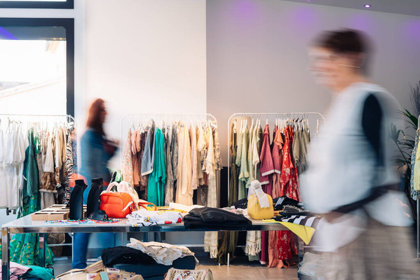 out of focus movement effect of two customers in a fashion shop. shopping concept. - Foto, Imagen