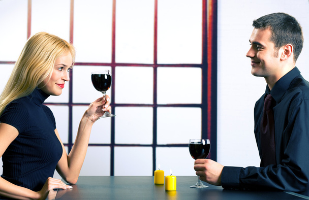Young happy couple celebrating with red wine, indoors - Fotografie, Obrázek