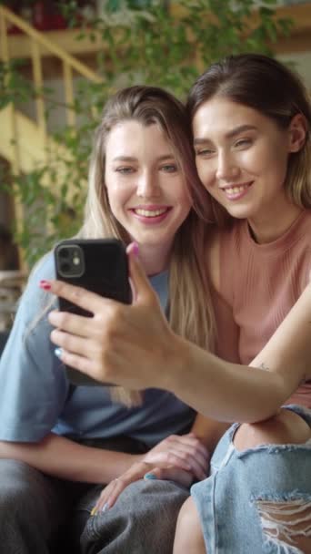 Two young lgbt ladies are talking with their friends on the video call, listening attentively and smiling. High quality FullHD footage - Footage, Video