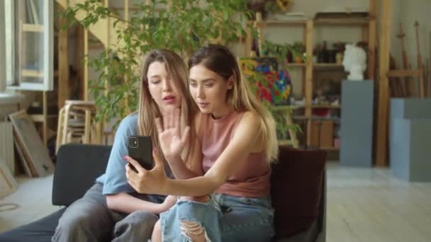 Dvě mladé lgbt dámy dojednají rozhovor se svými přáteli na videohovoru, mávají rukama a posílají polibek. Vysoce kvalitní FullHD záběry - Záběry, video