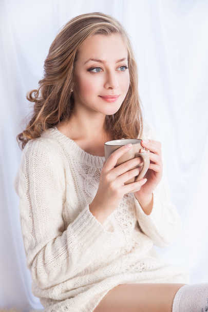 Woman enjoying coffee while relaxing at home - Fotoğraf, Görsel