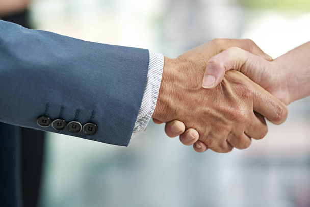 Extending a warm welcome. Closeup shot of businesspeople shaking hands in a modern office. - Foto, imagen