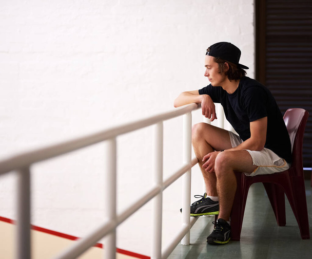 Hes got the best view in the court. Shot of a handsome young man watching a game of squash. - Photo, Image