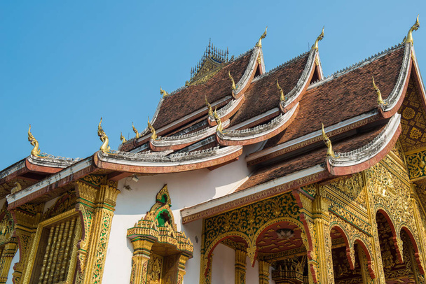 Schöne Außenfassade eines ikonischen buddhistischen Tempels im königlichen Palast von Luang Prabang, dem UNESCO-Weltkulturerbe im Norden von Laos. - Foto, Bild