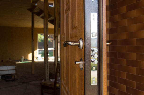 Safety lock on a new wooden front door - Φωτογραφία, εικόνα