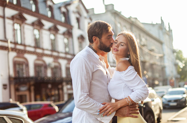 Romantic, love concept. Young couple in love kisses in the city at sunset - Photo, Image