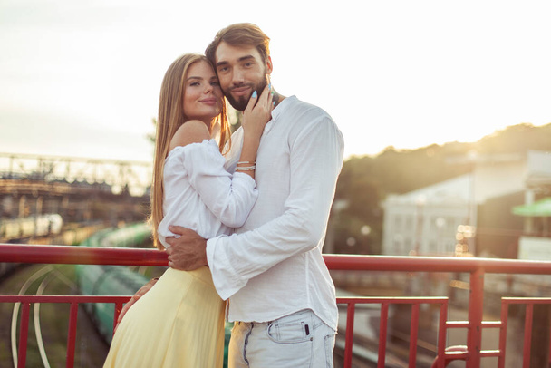 Portrait of young loving couple in urban location at sunset. Romantic concept - Photo, Image